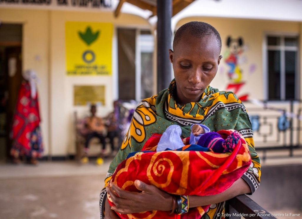 Donna in Tanzania con bambino con Malnutrizione